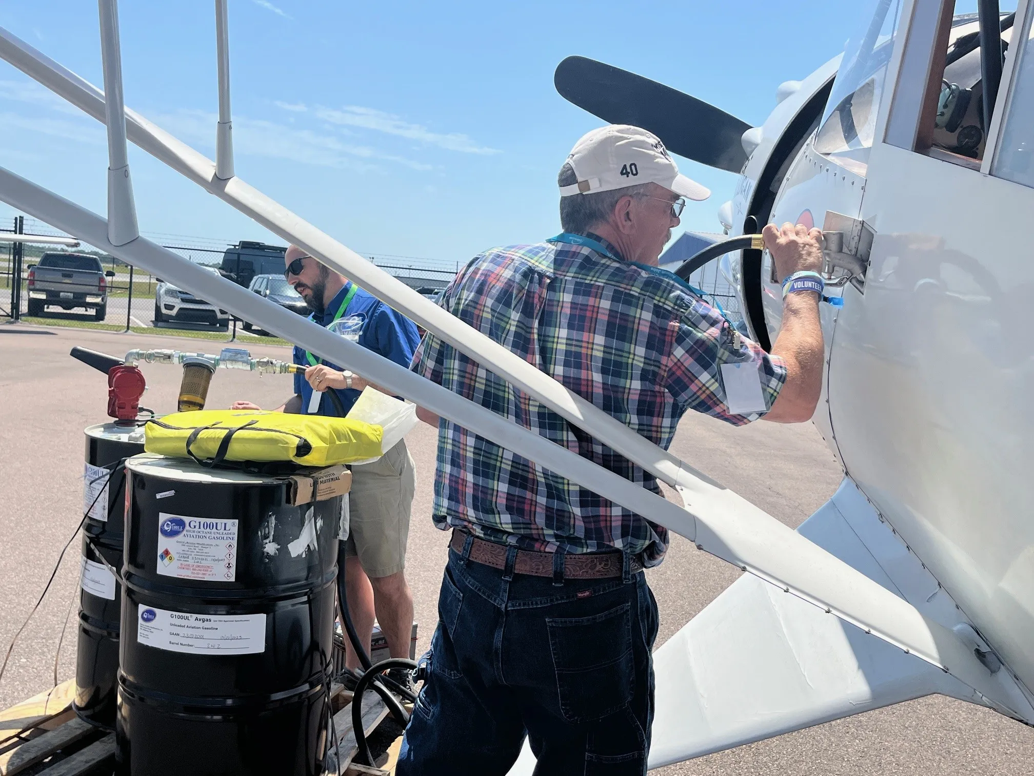 Two men refuel the famous airplane Howard DGA-6 replica, Mister Mulligan with G100UL unleaded avgas